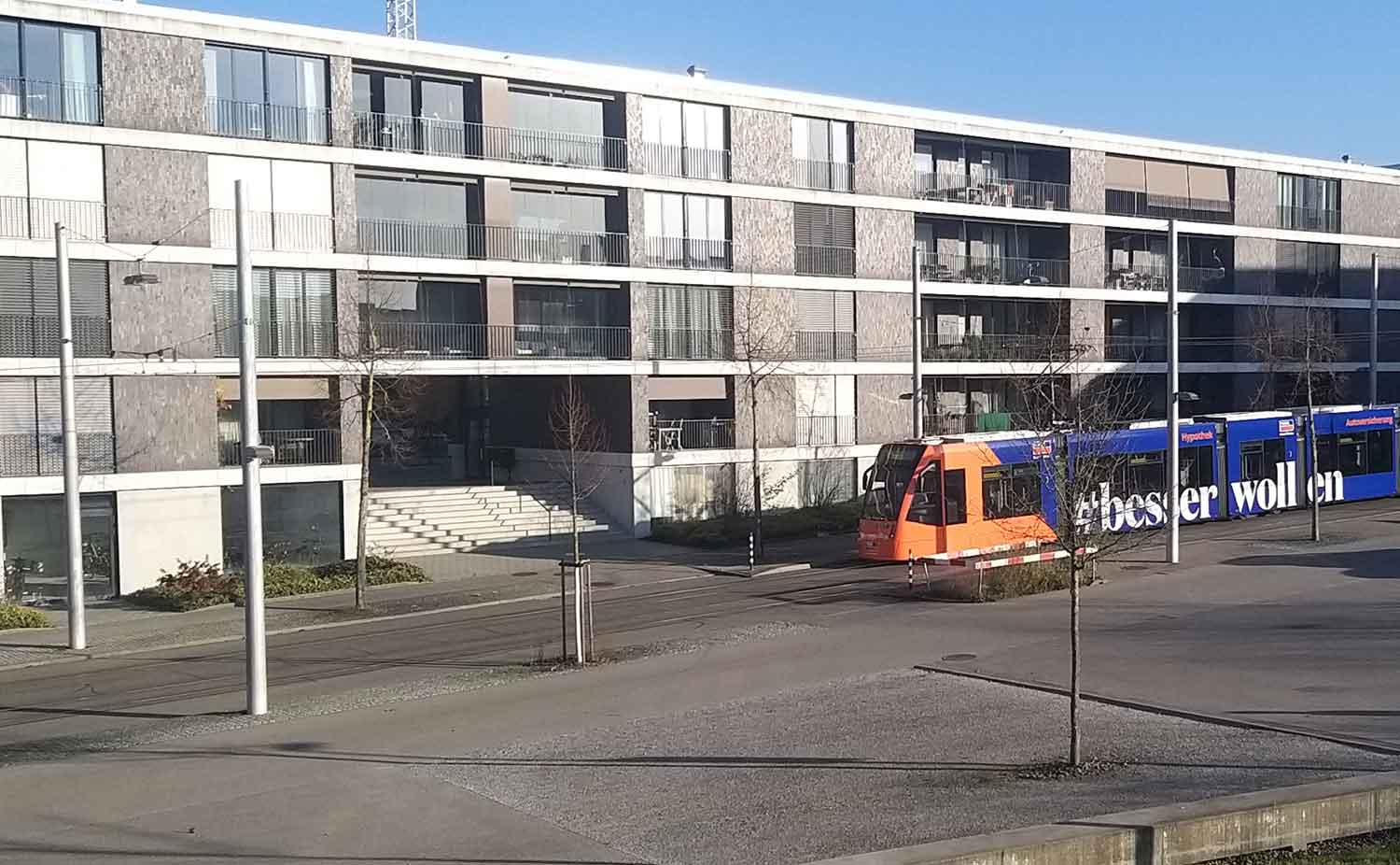 Ein Tram fährt vor einem Wohnhaus in Richtung Gäbelbach